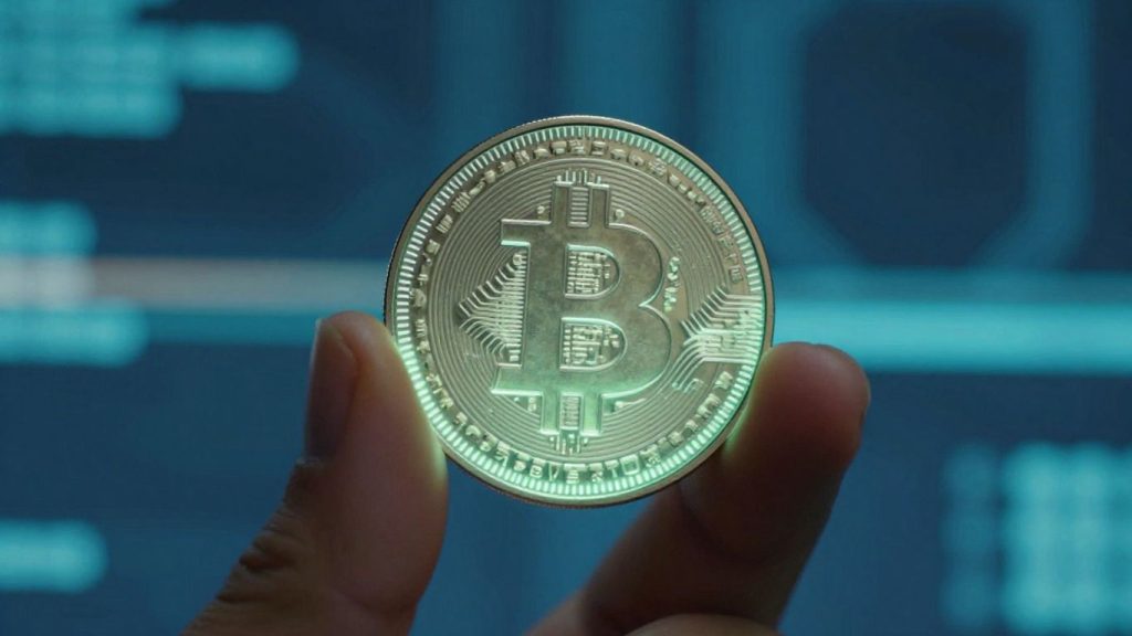 Hand holding a glowing digital coin, crypto recovery concept.